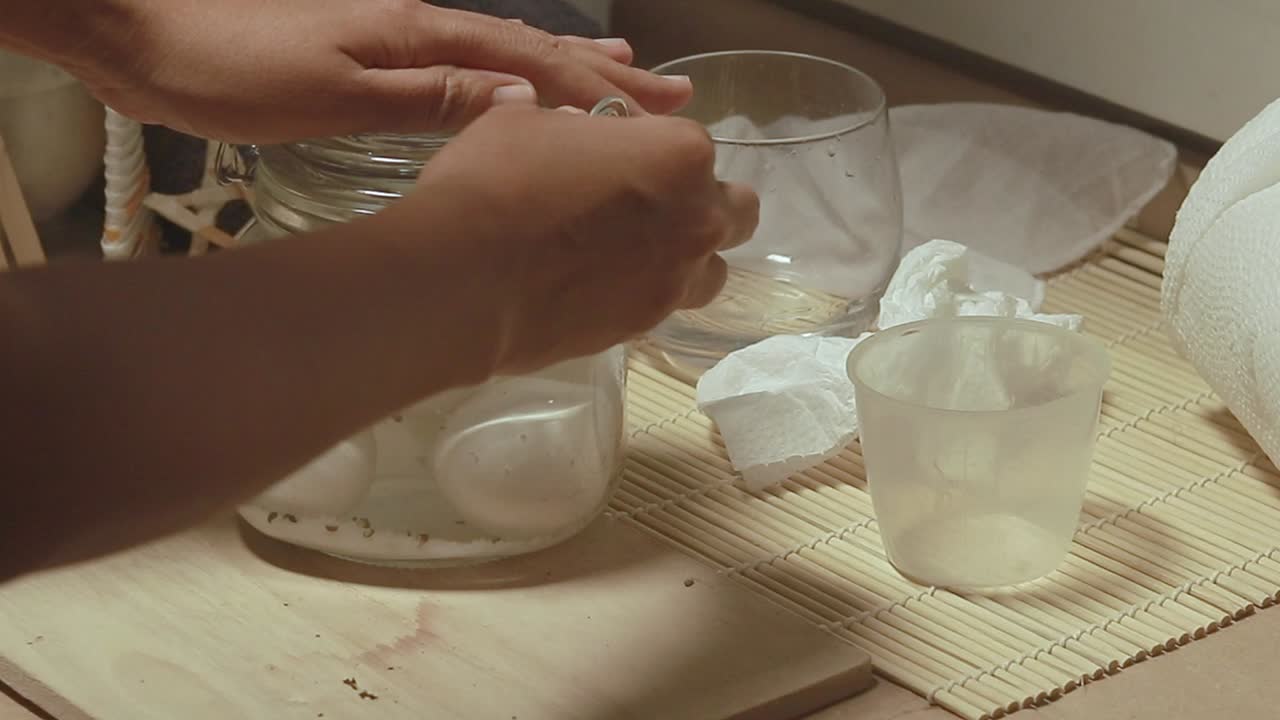 Adding more brine to a mason jar containing raw eggs following the classic traditional recipe for homemade salted eggs