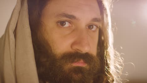 backlit portrait of man wearing robes with long hair and beard representing figure of jesus christ 1