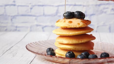 stack of pancakes with honey and blueberries