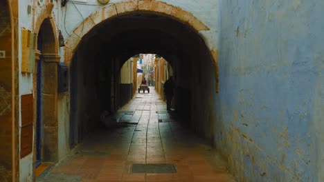 silhouettes of people walking in narrow streets of old town medina in essaouira