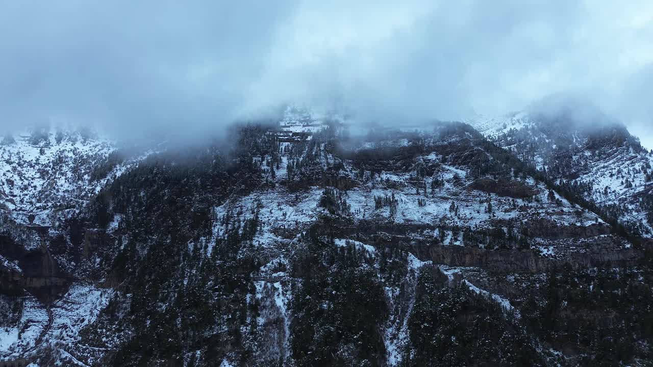 Snowy mountain range near Canfranc-Estación, with mist and dense forests