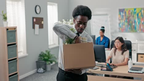 man with afro hair quits corporate job leaves office with things packed in box leaves corporate, checks to make sure he took everything, quits job, retires, happy smiling