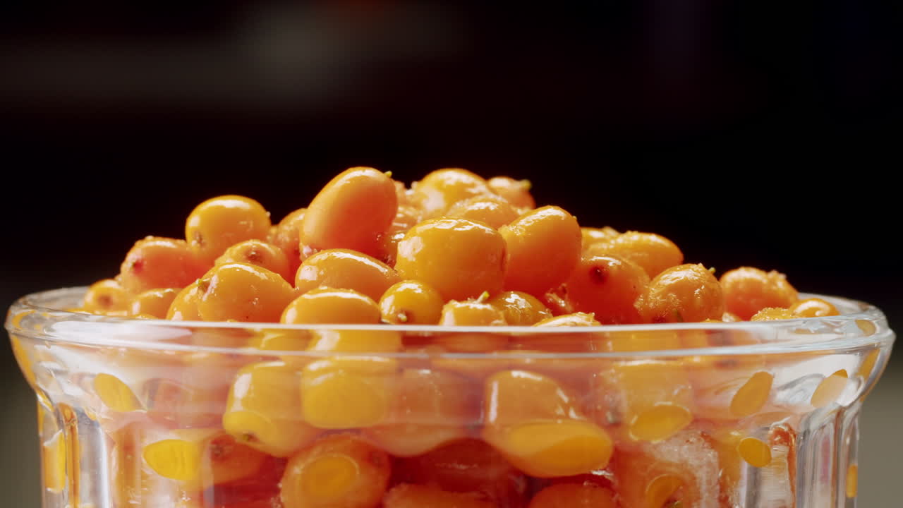 해바라기 건강한 베리 차 음료, 유리 항아리 및 잎을 가진 가지에 얼어붙은 익은 베리 어두운 나무 농촌 배경에  뷰, 피부, 심장, 혈관 및 면역 체계에 훌륭합니다.