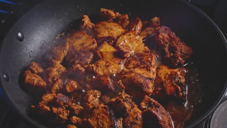 pouring water into fried chicken breast in a pan, cover and let it simmer