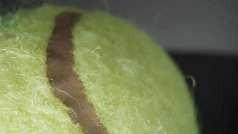 fluorescent yellow tennis ball lies on table near window