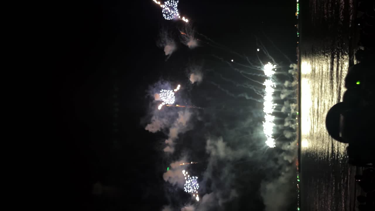 detalle de la captura de pantalla de la grabación de la cámara filmando un gran festival de fuegos artificiales cerca de la costa - video vertical