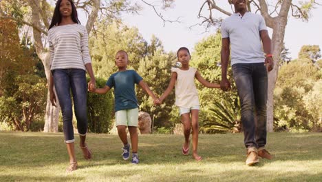 Vista-De-ángulo-Bajo-De-Familia-Feliz-Tomados-De-La-Mano-Y-Caminando