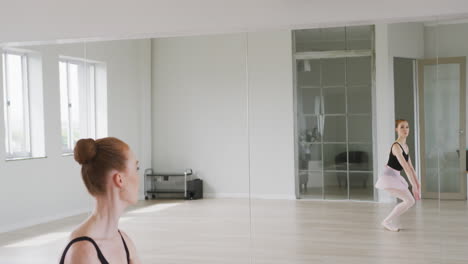 caucasian female ballet dancer practicing ballet during a dance class in a bright studio