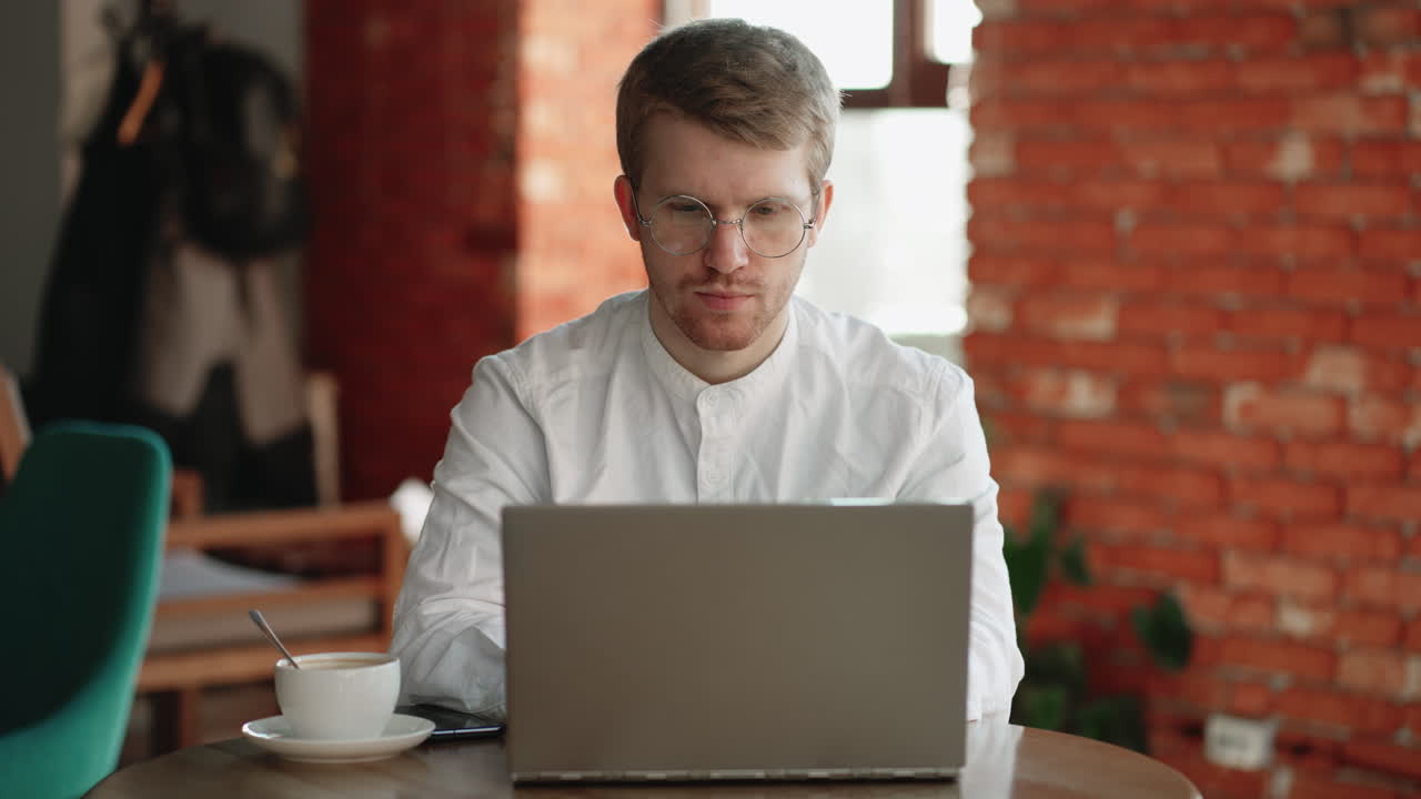 hombre freelancer está trabajando con una computadora portátil en un acogedor café y bebiendo café modelo de trabajo remoto y trabajo a tiempo parcial en línea