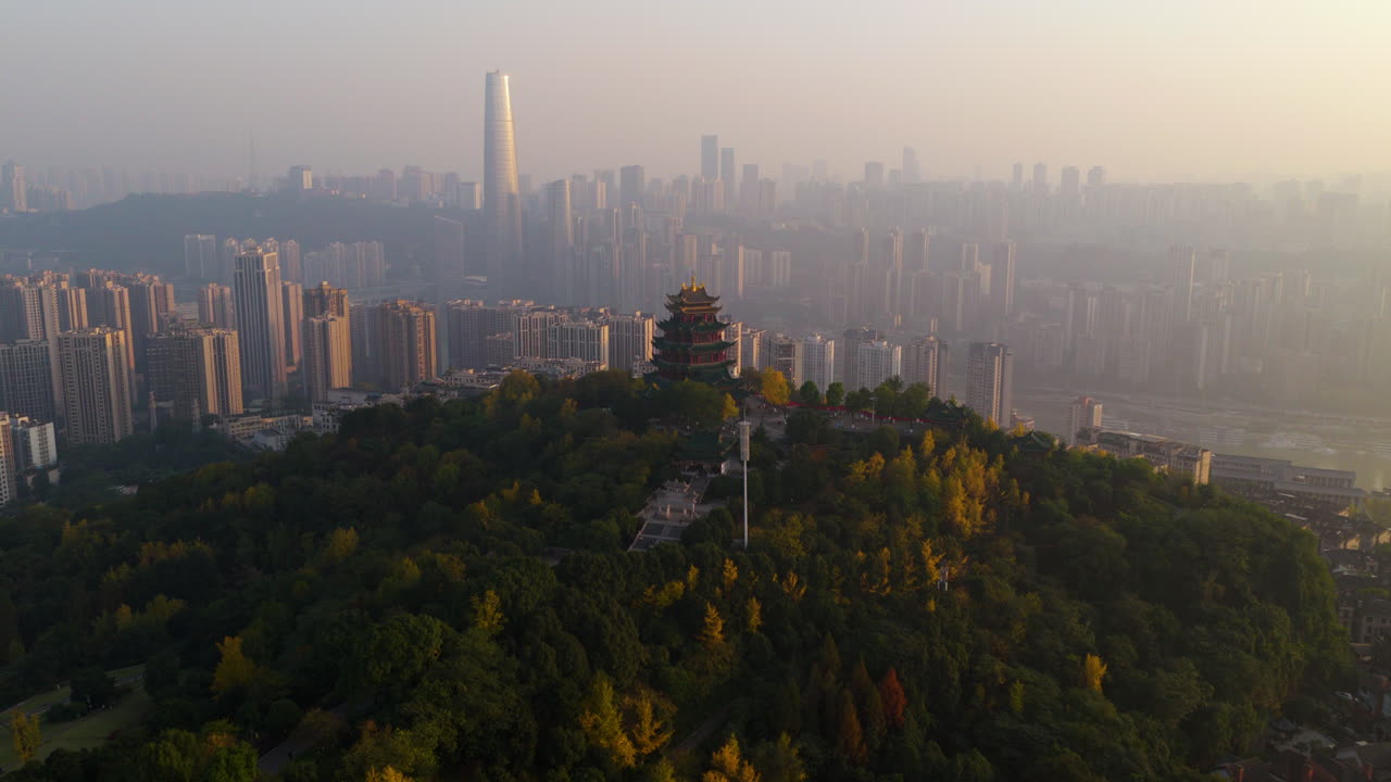 Hong'en Pavilion On Forested Longji Mountain At Dusk With Chongqing Skyline In China. - aerial shot