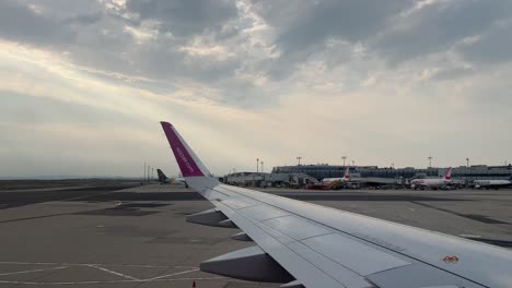 wizz air plane wing in the international airport of vienna, flughafen wien-schwechat during the day 4k