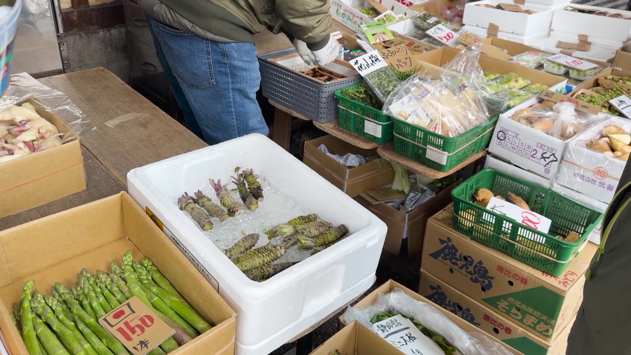 High angle shot of fresh wasabi roots on ice and asparagus at a Japanese market