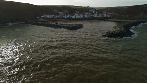 Niedrige-Drohnenaufnahme-Von-Staithes-Und-Hafen-An-Einem-Sonnigen-Tag-In-Großbritannien