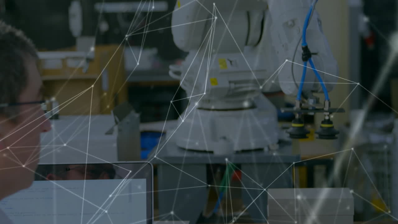 animazione di una rete di connessioni su un ingegnere maschio caucasico che usa un portatile, che opera un braccio robot