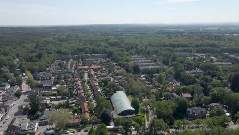 descripción aérea de un pequeño pueblo rodeado por un bosque verde en verano