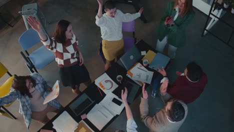 grupo de personas de negocios felices celebran el éxito del trabajo en equipo uniendo manos, los cinco altos en la oficina en cámara lenta.