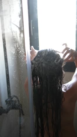 mujer lavándose el cabello en la ducha
