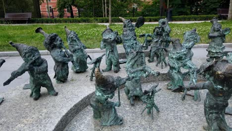 Cute-and-quirky-dwarf-sculpture-orchestra-outdoors-in-Wroclaw,-Poland,-Panning