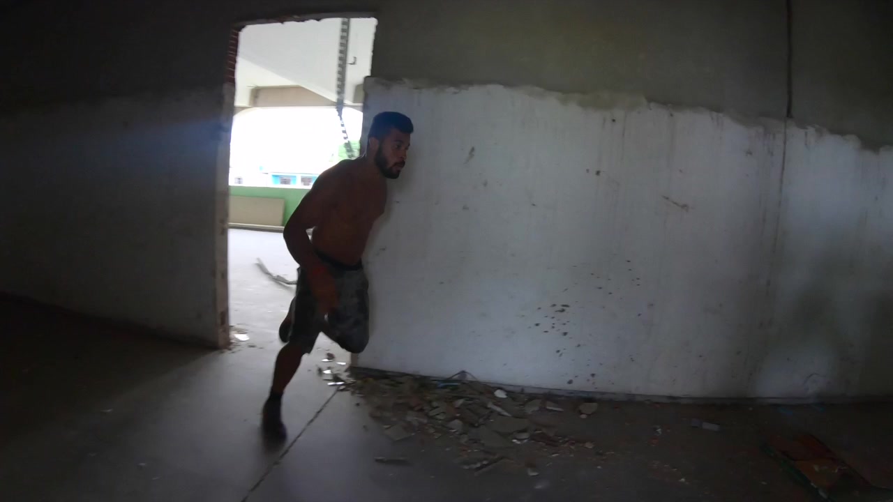 Due freerunner che scappano da una stanza, correndo lungo un pavimento e finendo intrappolati da una recinzione.