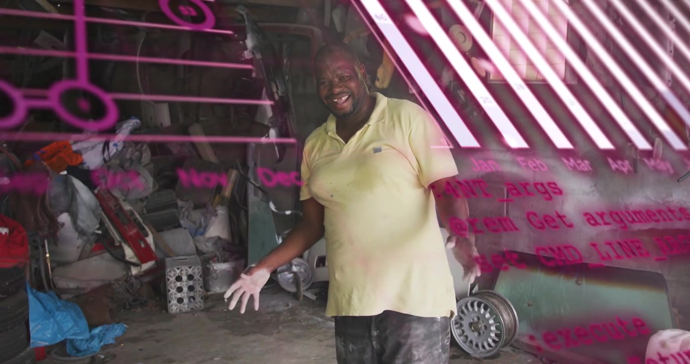 Video verticale: Uomo in un'officina automobilistica che risponde a sovrapposizioni magenta, muovendosi e gesticolando