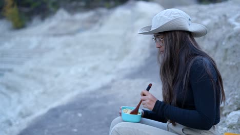 woman eating lunch outdoors in volcanic landscape