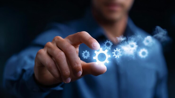 En person, der manipulerer digitale gear i et mørkt miljø, symboliserer automatisering, teknologi og innovation i moderne industrier og repræsenterer styrken ved Industri 4.0 og digital transformation.