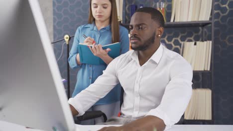 successful black businessman gets daily data analysis and information about jobs by his female assistant.