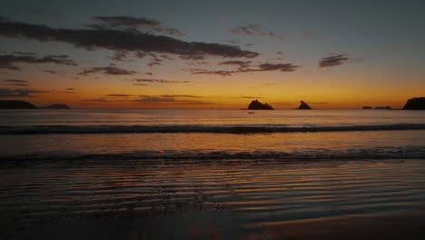 Puesta-De-Sol-En-Una-Hermosa-Playa-Con-Olas-Tranquilas-En-Guanacaste,-Costa-Rica---Toma-Aérea-De-Drones