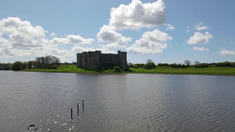 drone flying over river with carew castle in background, wales