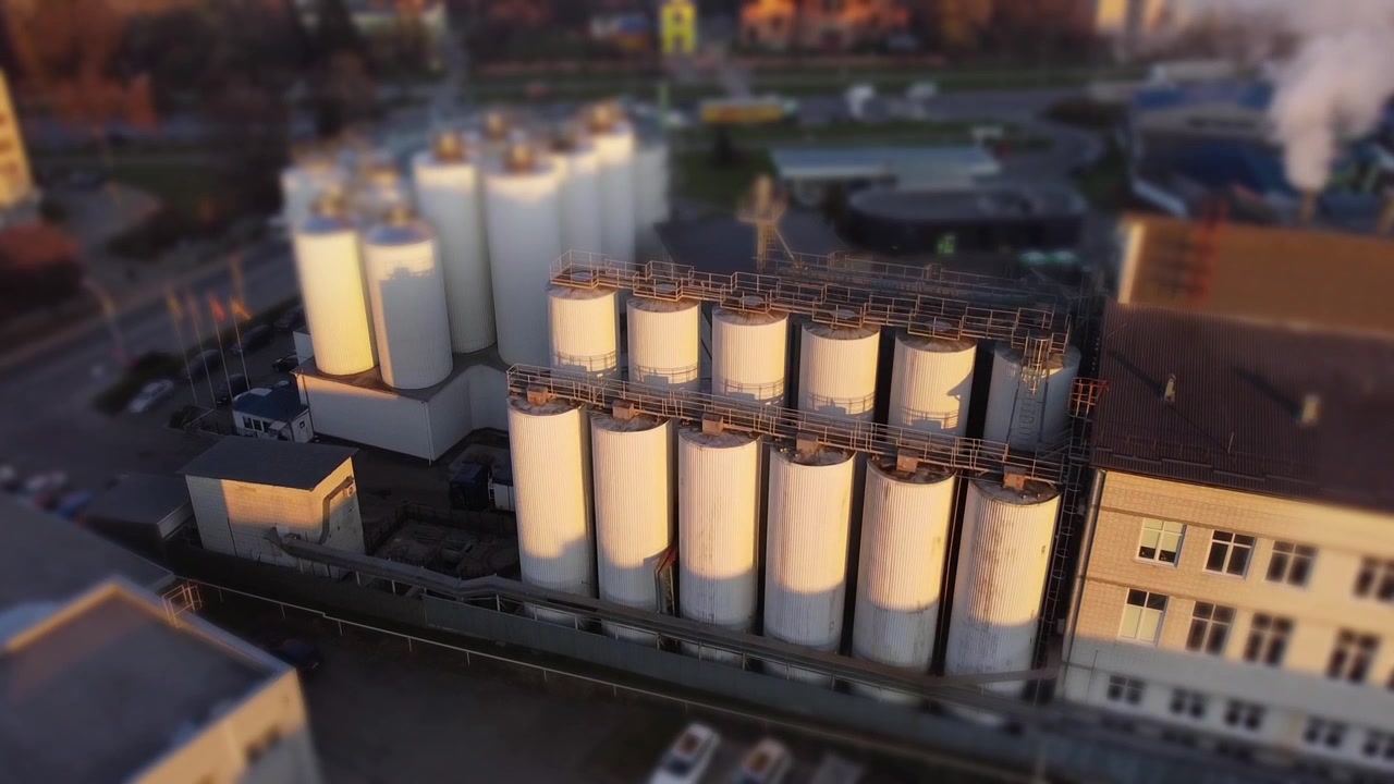 Aerial view of a drone flying over the beer production plant, several rows of tanks.