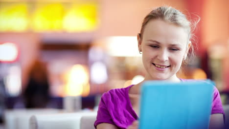 mujer en un café usando su touchpad