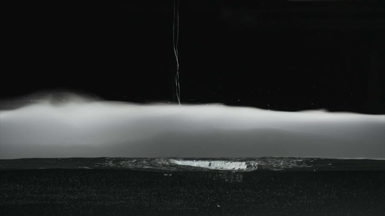 Slow motion dry ice fog-vapor floating on surface of water and bubbling in water. For use with visual effects and-or texturing and design.