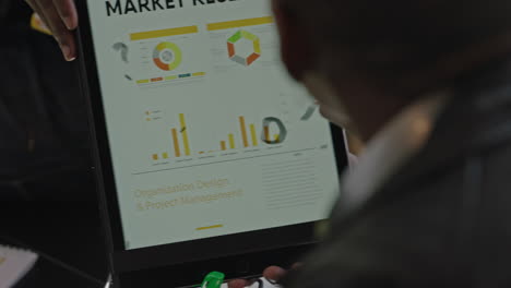 business people meeting businessman using tablet computer presenting marketing research statistics on screen sharing market information to creative colleagues in office presentation close up hands