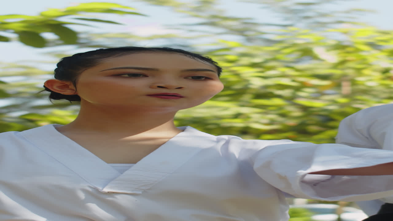 Vertical of Female Taekwondo Fighter Doing Jab Punches outdoors