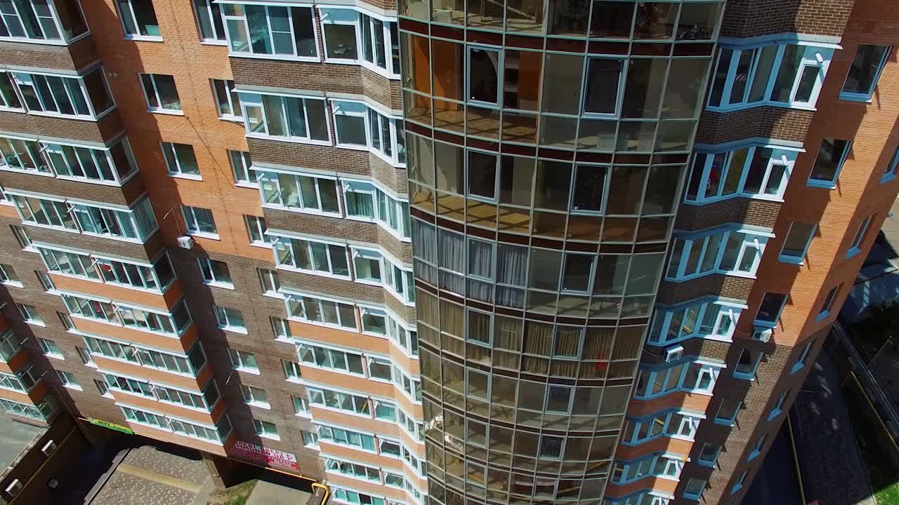 Modern skyscraper in the city center. New block of flats in the residential area. Exterior of high-rise architecture with balconies and windows.