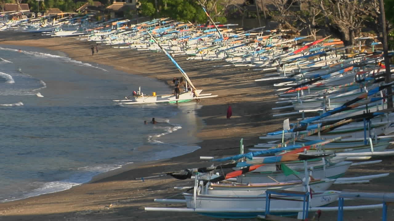 다채로운 보트가 인도네시아의 해변을 따라 당겨집니다.