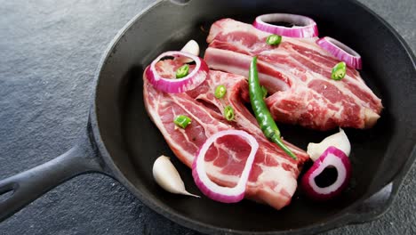 carne cruda y ingredientes en la sartén