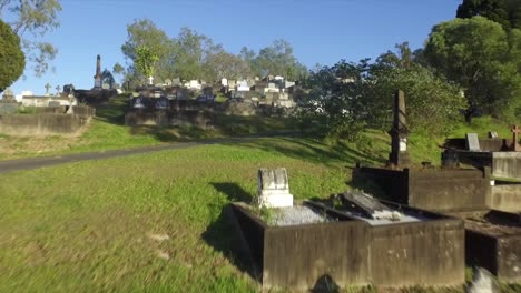 aerial drone low level flyover shot of graves, rising up at hillside