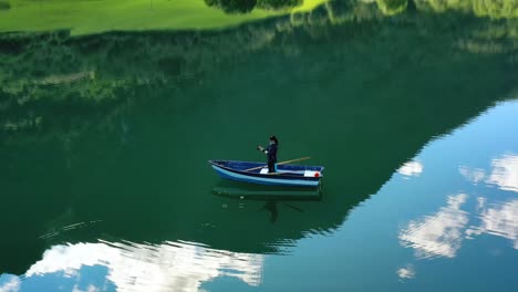 woman on the boat catches a fish on spinning in norway.