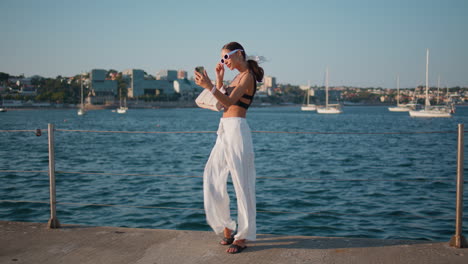 woman taking a selfie on a pier overlooking the ocean