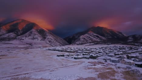 alpine glow cast on the snowy mountains over a small town in utah