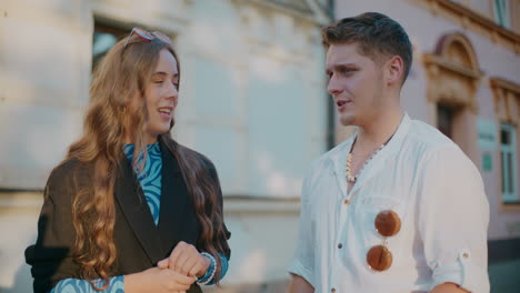 una pareja joven hablando en la calle.