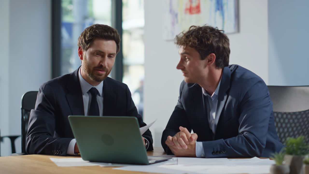 Businesspeople talking virtual meeting looking laptop in private room closeup