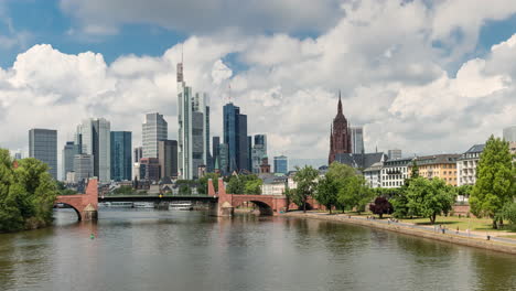 frankfurt skyline - barge cruising at main river with high-rise buildings, skyscrapers and frankfurt cathedral in background in germany