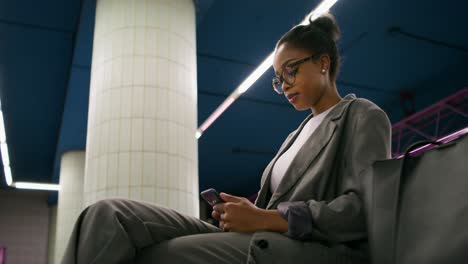 woman using smartphone in a subway station