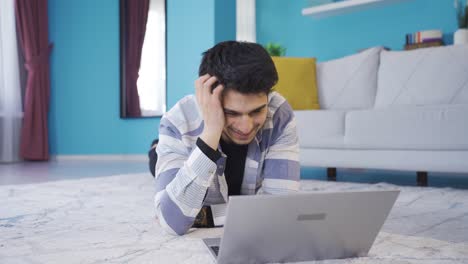 joven charlando con su novia en la computadora portátil y riendo emocionado.