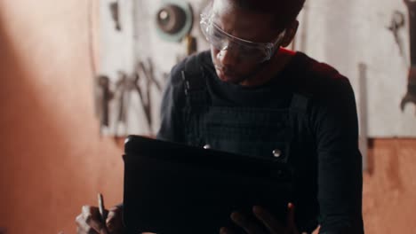 mechanic working on digital blueprints in a workshop