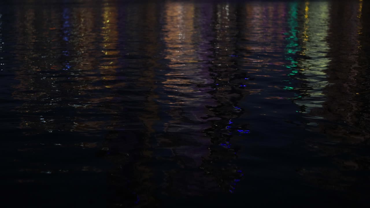 luces coloridas que se reflejan en el agua por la noche