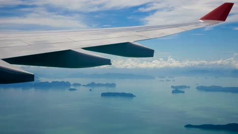 view from the window of an airplane flying over the sea with tropical islands