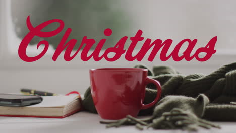 animación de saludos de navidad texto sobre taza roja y decoraciones de navidad.